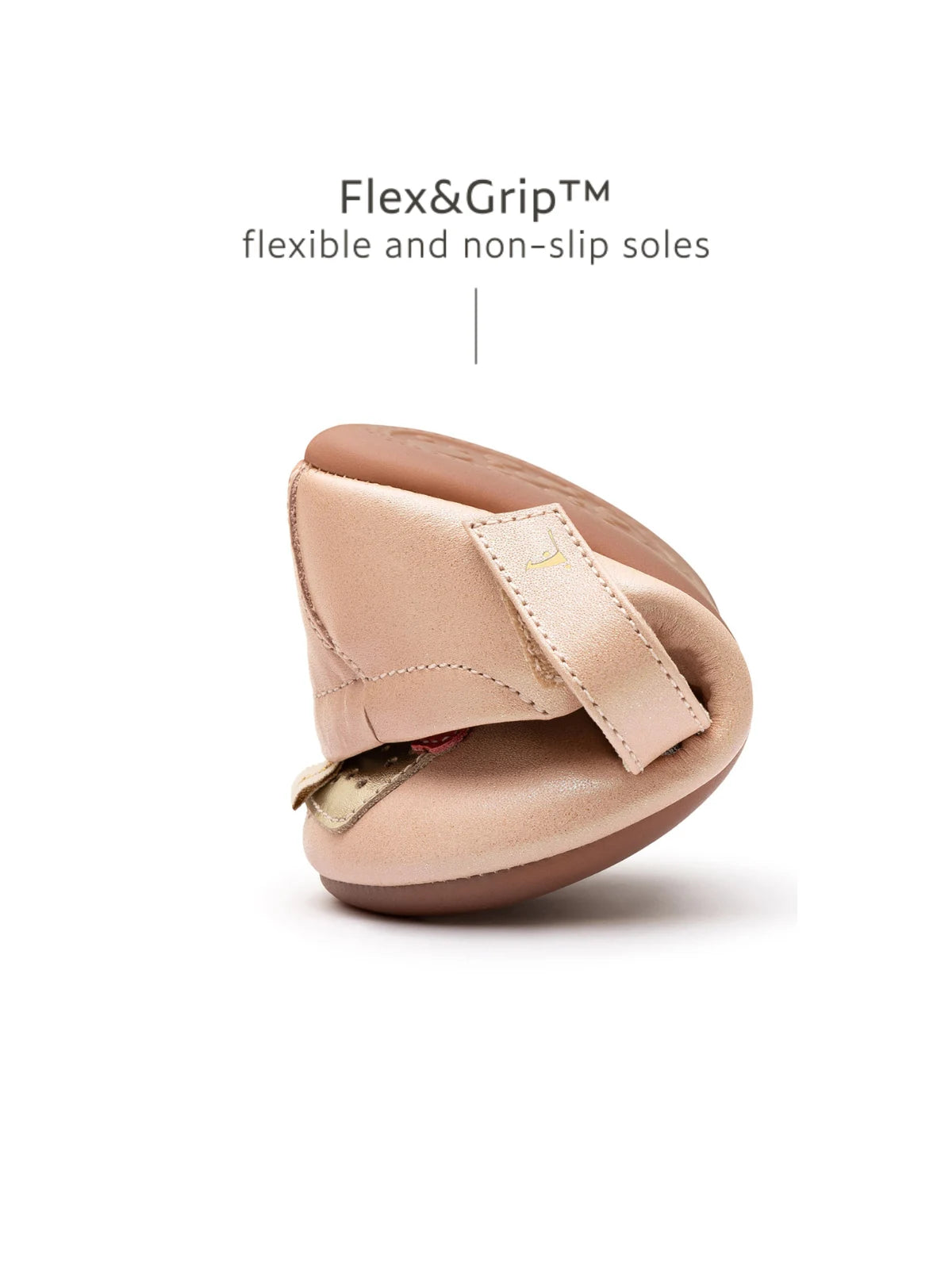 A pink baby shoe folded in half to show the Flex&Grip ultra-flexible, non-slip sole.