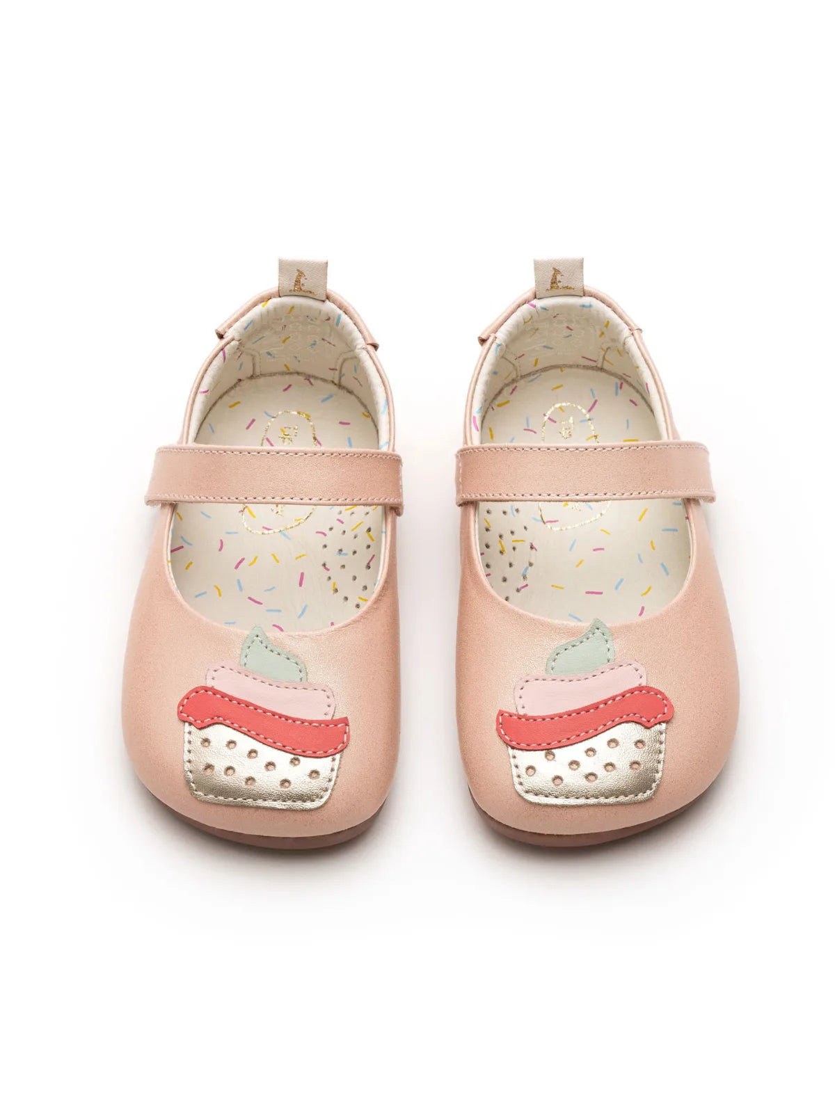 A pair of pink baby shoes seen from above, highlighting the cupcake design on the toes and the wide, foot-shaped toe box.