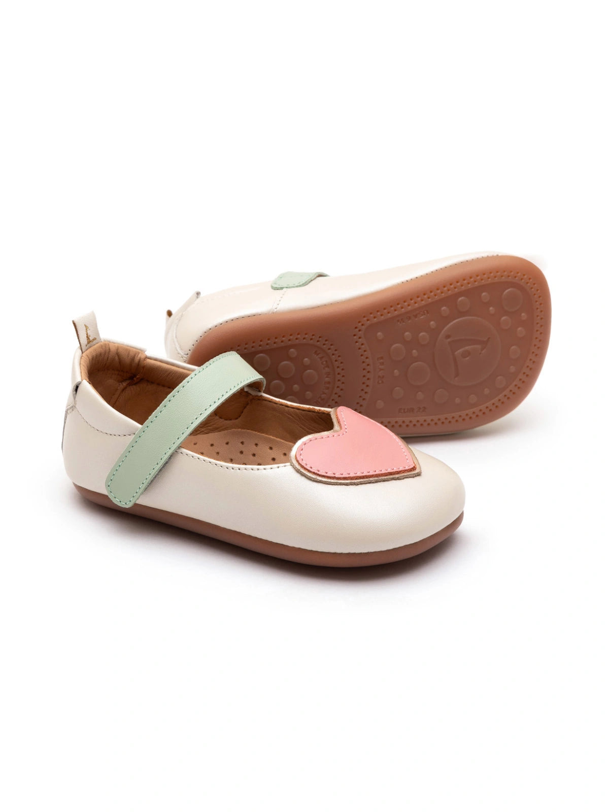 Antique white leather baby Mary Janes with a pink heart detail on the toe and a soft mint green adjustable strap.