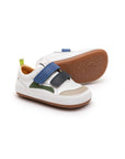 White leather baby sneakers with navy and blue tang accents, featuring double straps and a gum rubber sole.