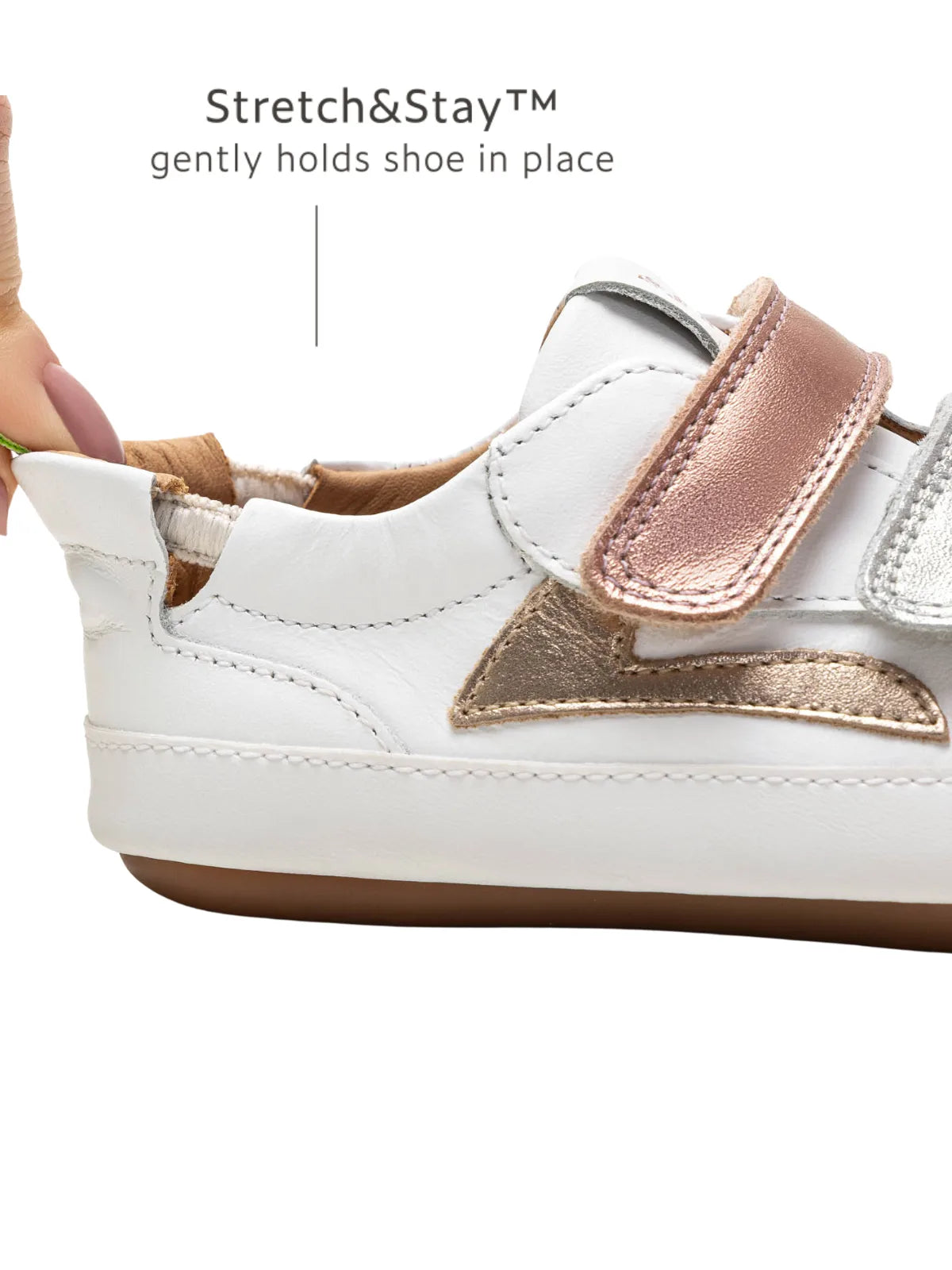 Close-up of the Stretch & Stay elastic heel and rose gold accent on the Landy baby sneaker for easy dressing.