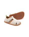 Tapioca off-white leather baby sandals with a closed toe, adjustable strap, and flexible gum rubber sole.