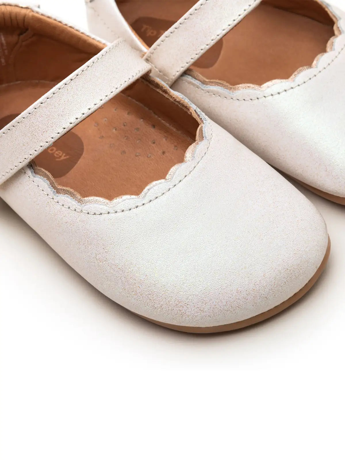 Close-up of the delicate scalloped edge and premium white dream leather finish on the baby Roundy shoe.