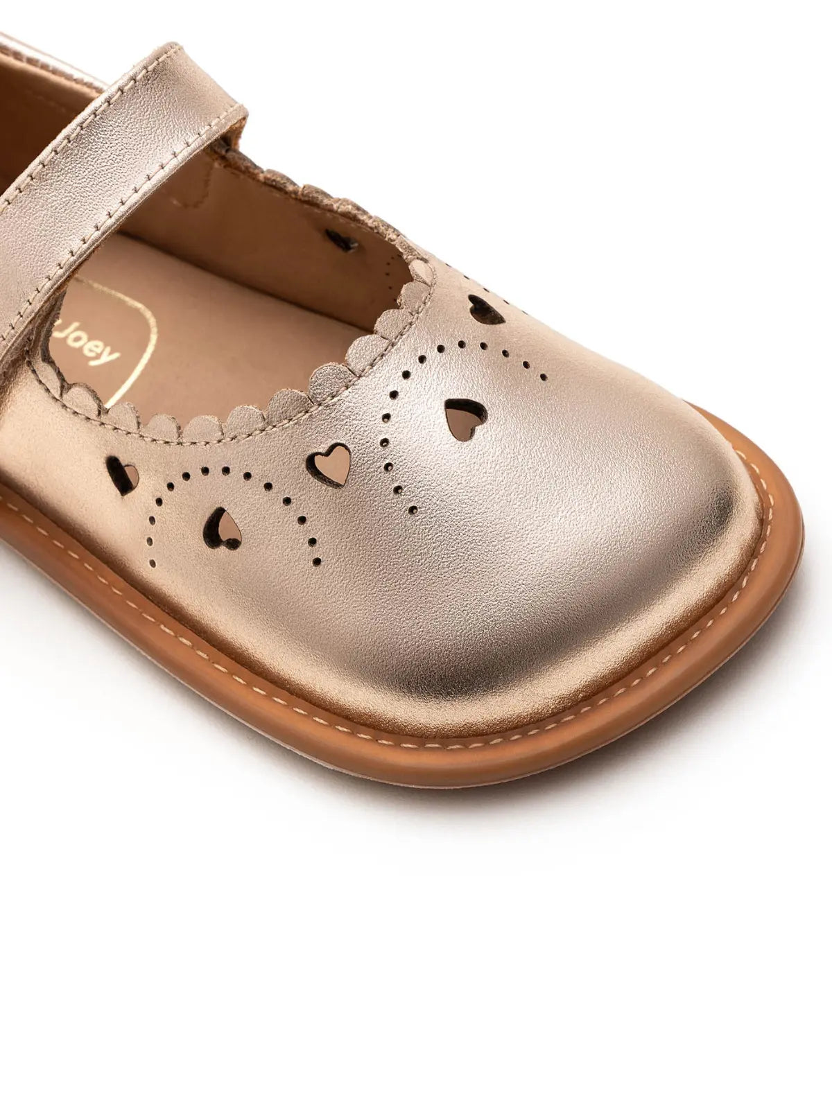 Close-up of the premium metallic salmon leather and intricate heart-shaped cut-outs on the baby Mary Jane toe.