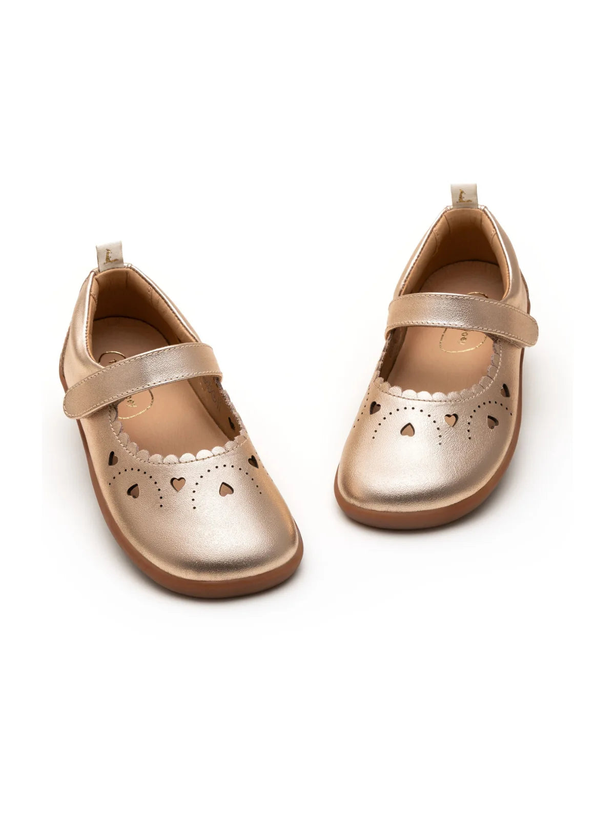 Angled view of kids metallic salmon Mary Janes showing the secure strap and decorative heart toe detail.