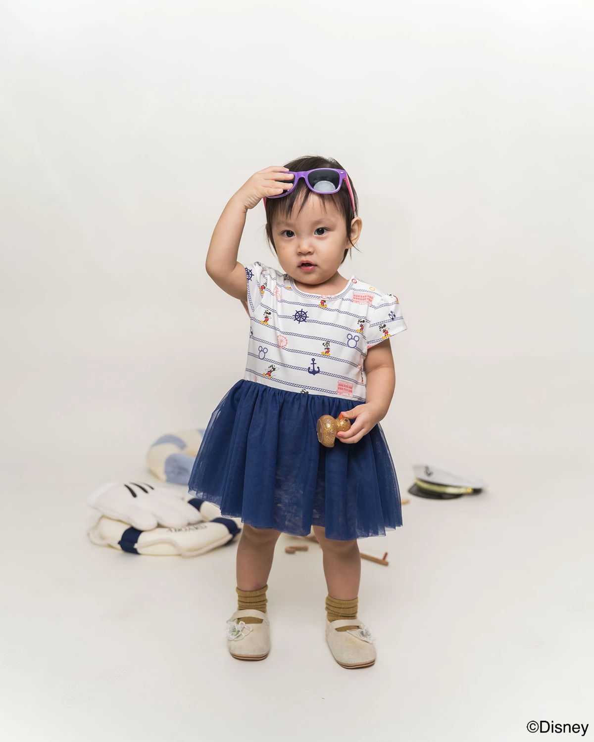 Child wearing Tulle onesie nautical mickey and holding sunglasses