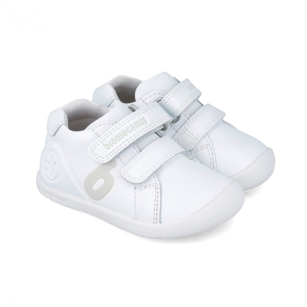 White baby sneakers with velcro straps on a white background