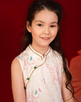 Smiling girl in a patterned dress against a red background.