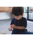 Child playing with PlanToys Geo Matching Blocks